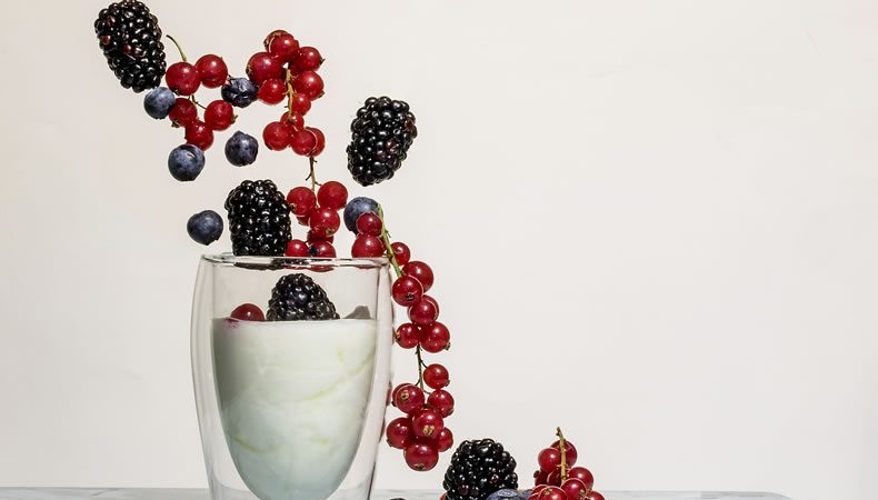 bicchiere di yogurt bianco al naturale con frutti di bosco